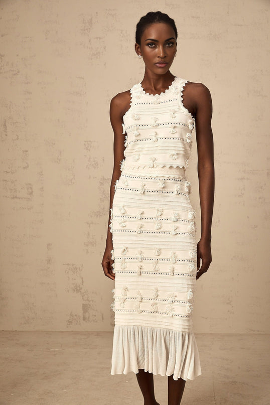 Woman wearing white knit top and skirt set with pointelle trim details Paola matching outfit