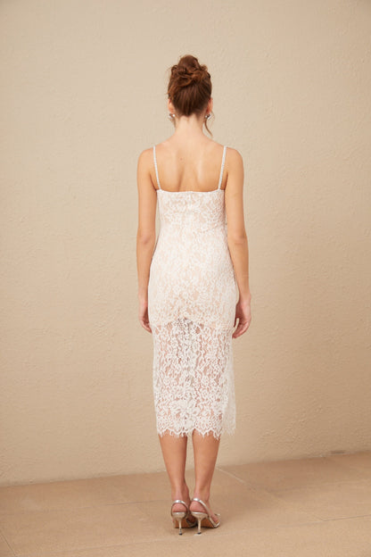 Woman wearing white lace midi dress with crystal embellished bustier top and fitted silhouette