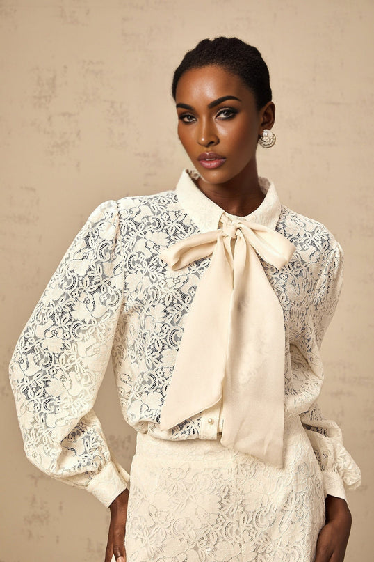 Woman wearing white lace shirt and matching trousers set with intricate guipure lace pattern