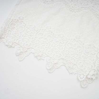Woman wearing white lace trim cropped top and matching trousers with cutout details Raphaelle matching set