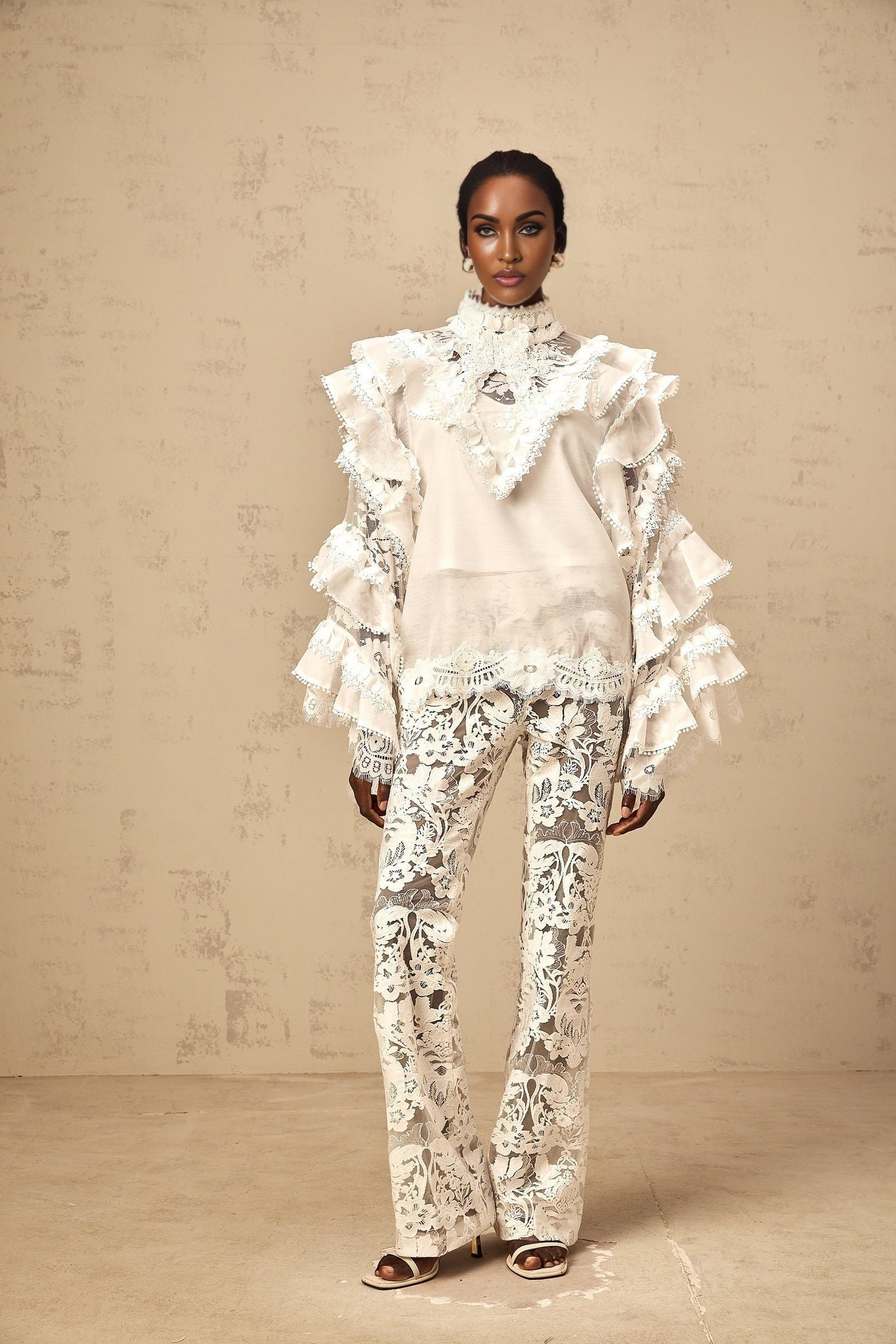 Woman wearing white layered lace blouse with tie detail at neckline
