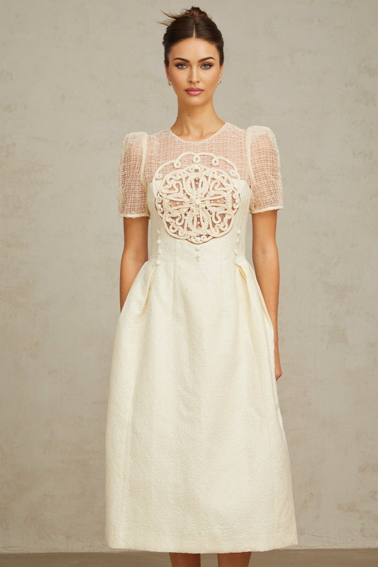 Woman wearing white midi dress with braided panelling and sleeveless design