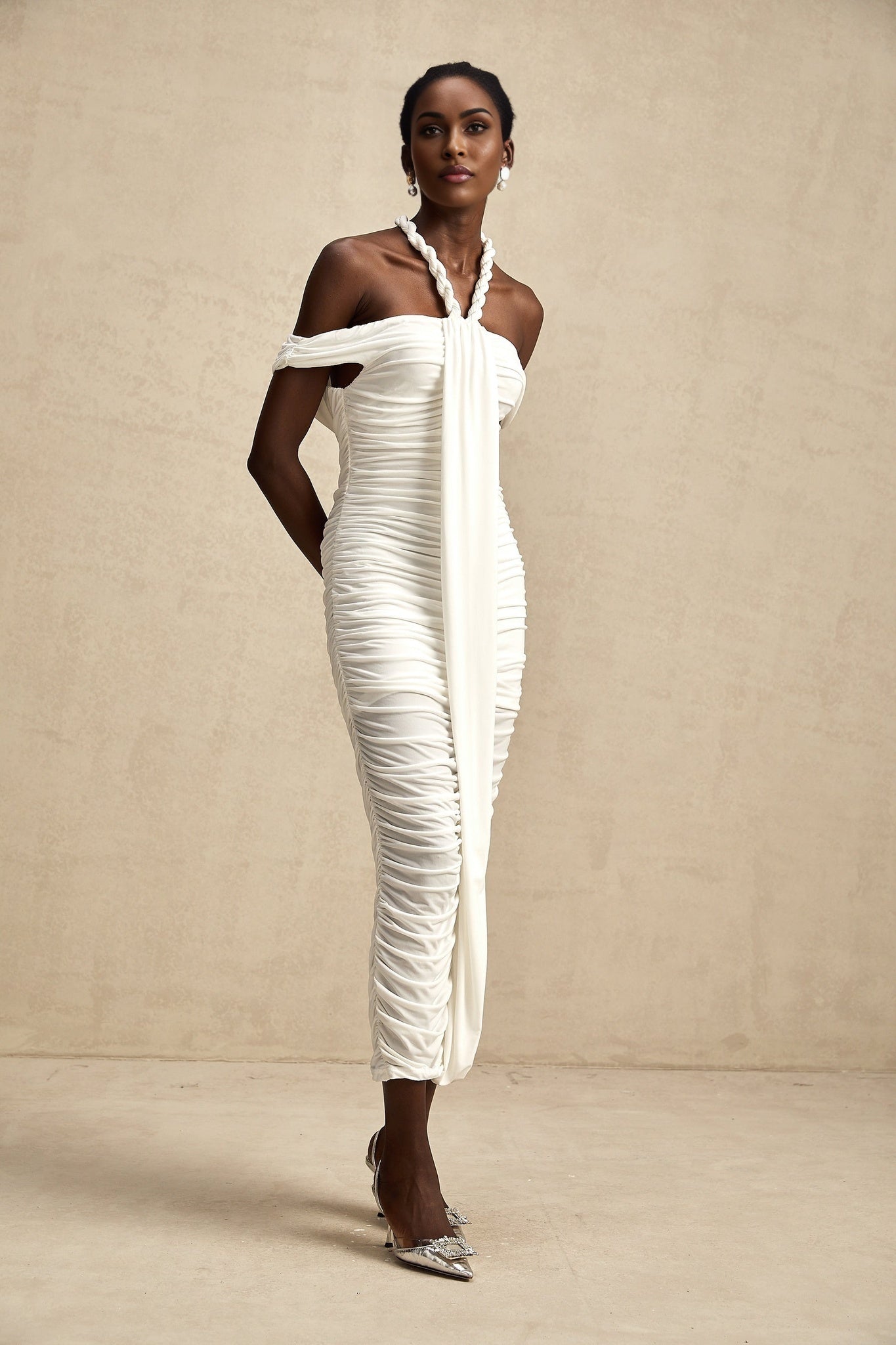 Woman wearing white midi dress with braided rope details and sleeveless design