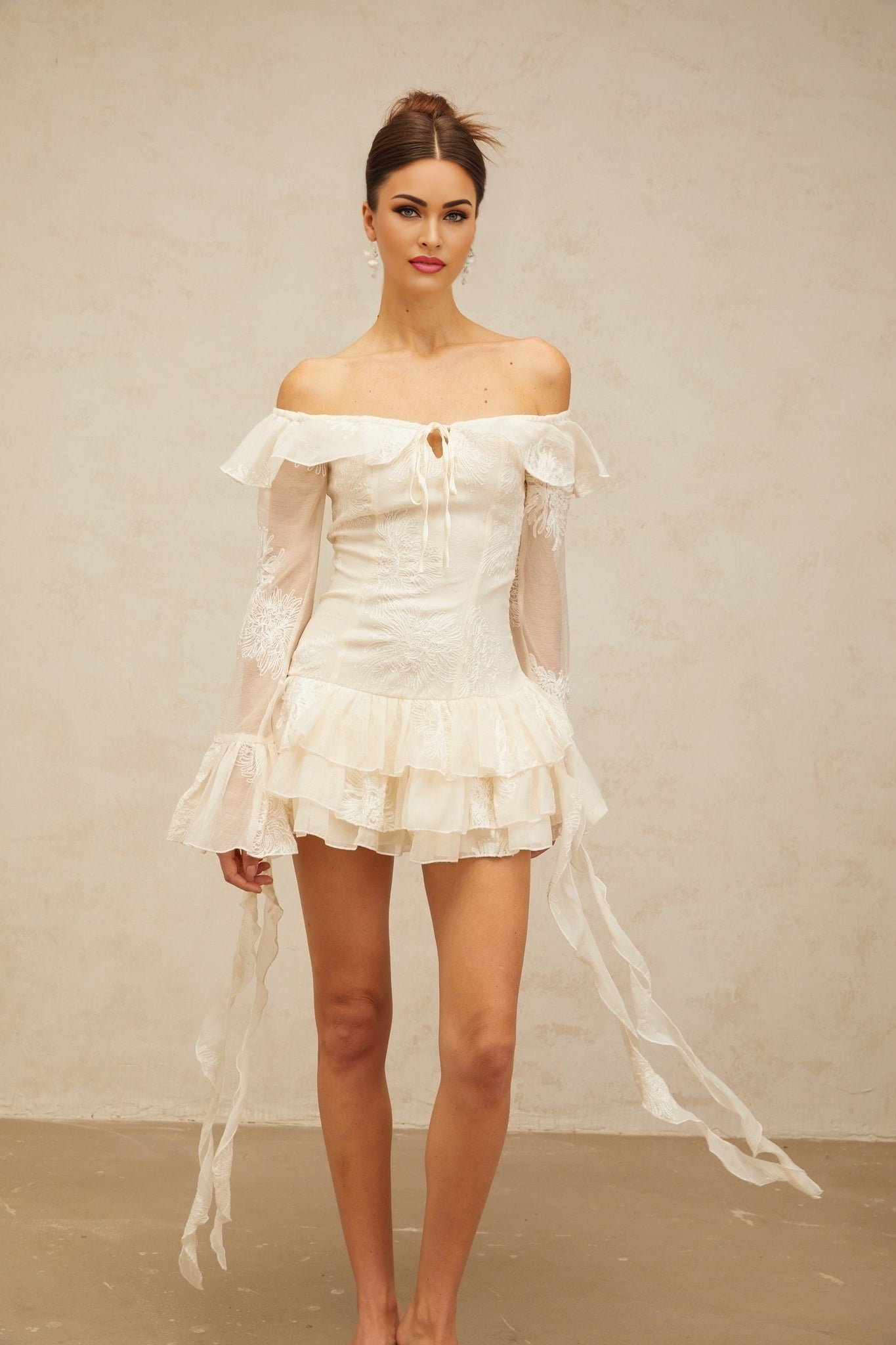 Woman wearing white off shoulder mini dress with embroidery details