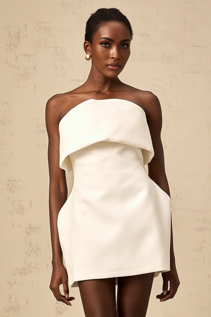 Woman wearing white off shoulder mini dress with puff sleeves against plain background