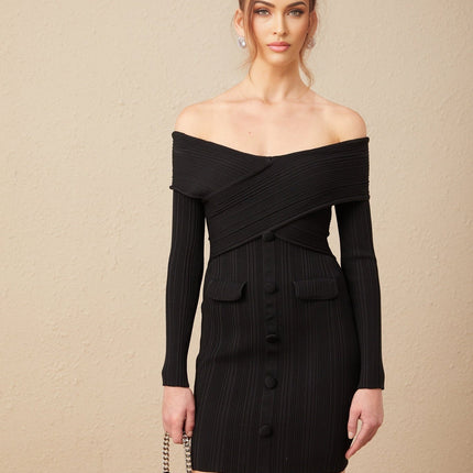 Woman wearing white offshoulder ribbed knit mini dress with short sleeves standing against plain background