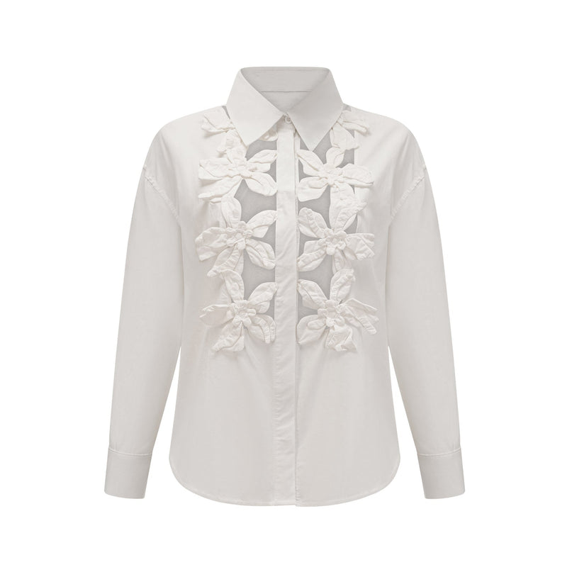 Woman wearing white shirt with floral pattern and cut out details