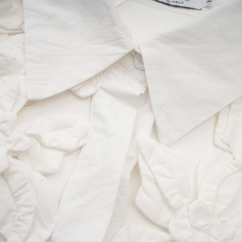 Woman wearing white shirt with floral pattern and cutout details