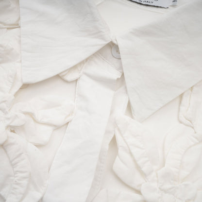 Woman wearing white shirt with floral pattern and cutout details