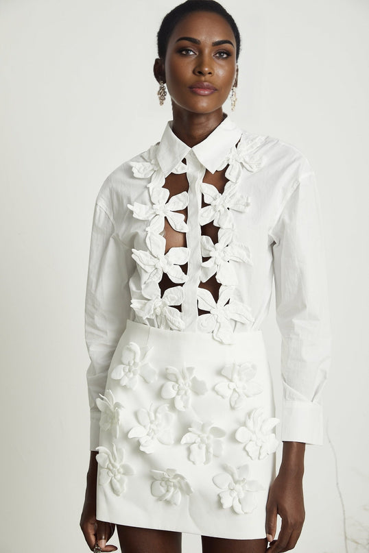Woman wearing white shirt with floral pattern and cutout details