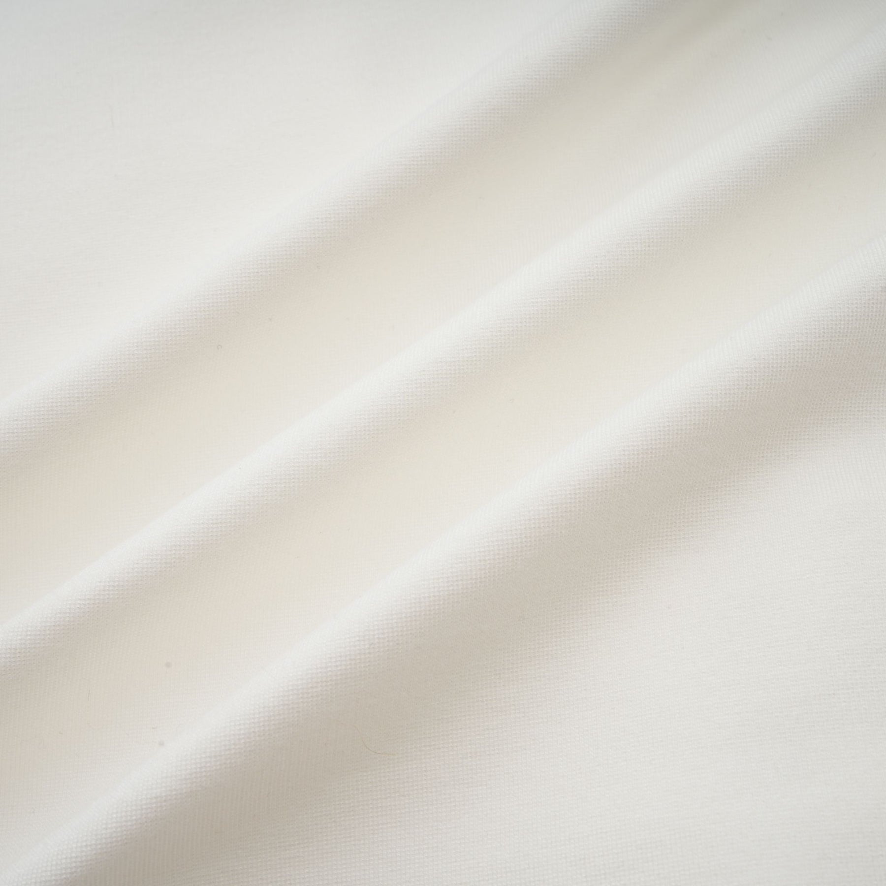 Woman wearing white sleeveless ruched crop top with gathered fabric detail