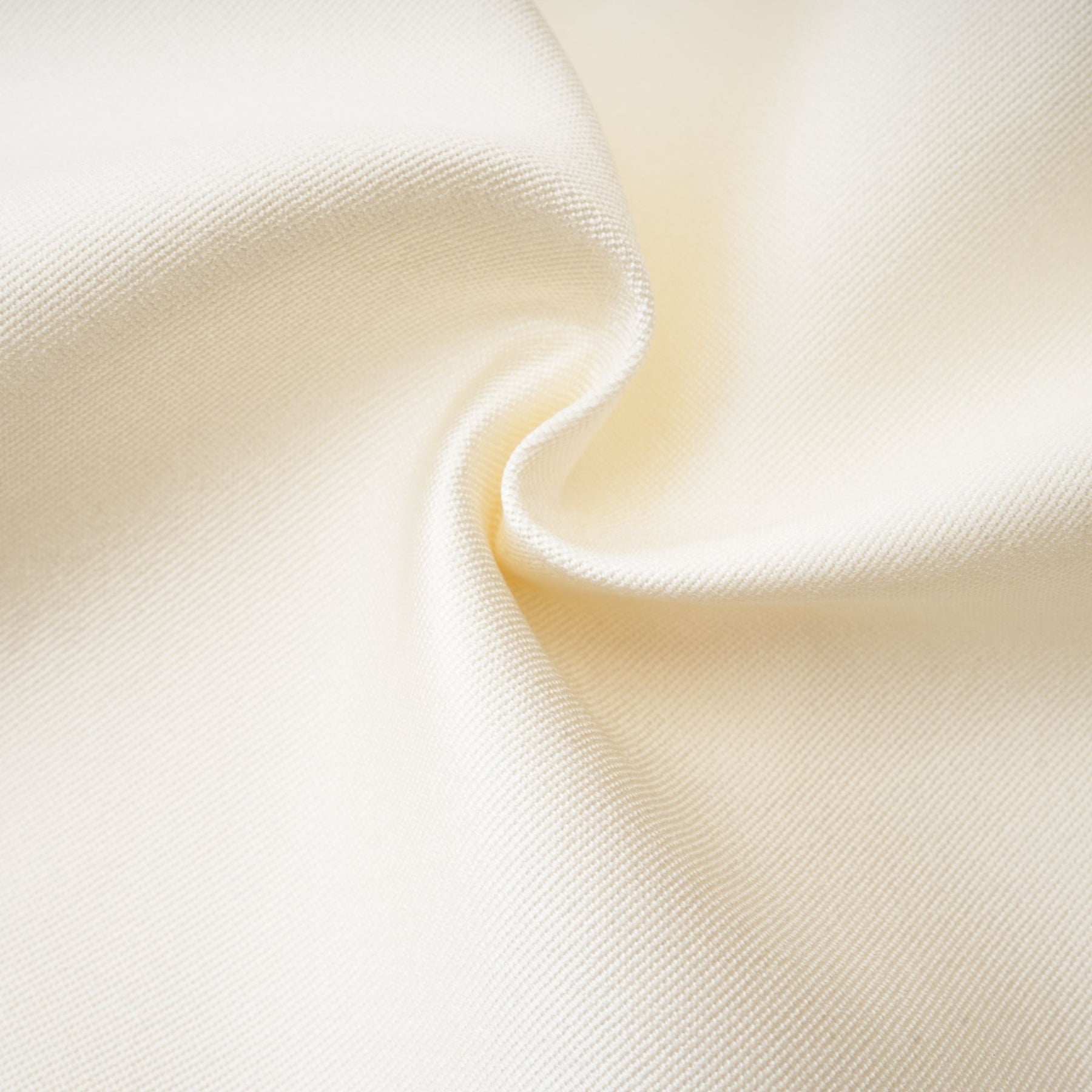 Woman wearing white sleeveless top and matching white skirt standing against plain background