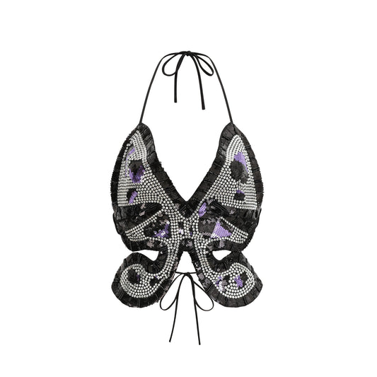 Woman wearing white sleeveless top with colorful butterfly embellishment on front