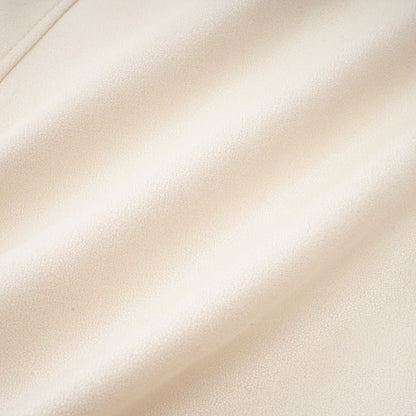 Woman wearing white suede short coat with fur trim and padded design