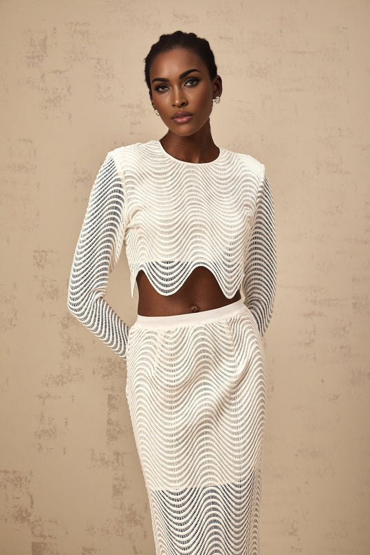 Woman wearing white wavy woven top and matching skirt set named Constance standing against plain background