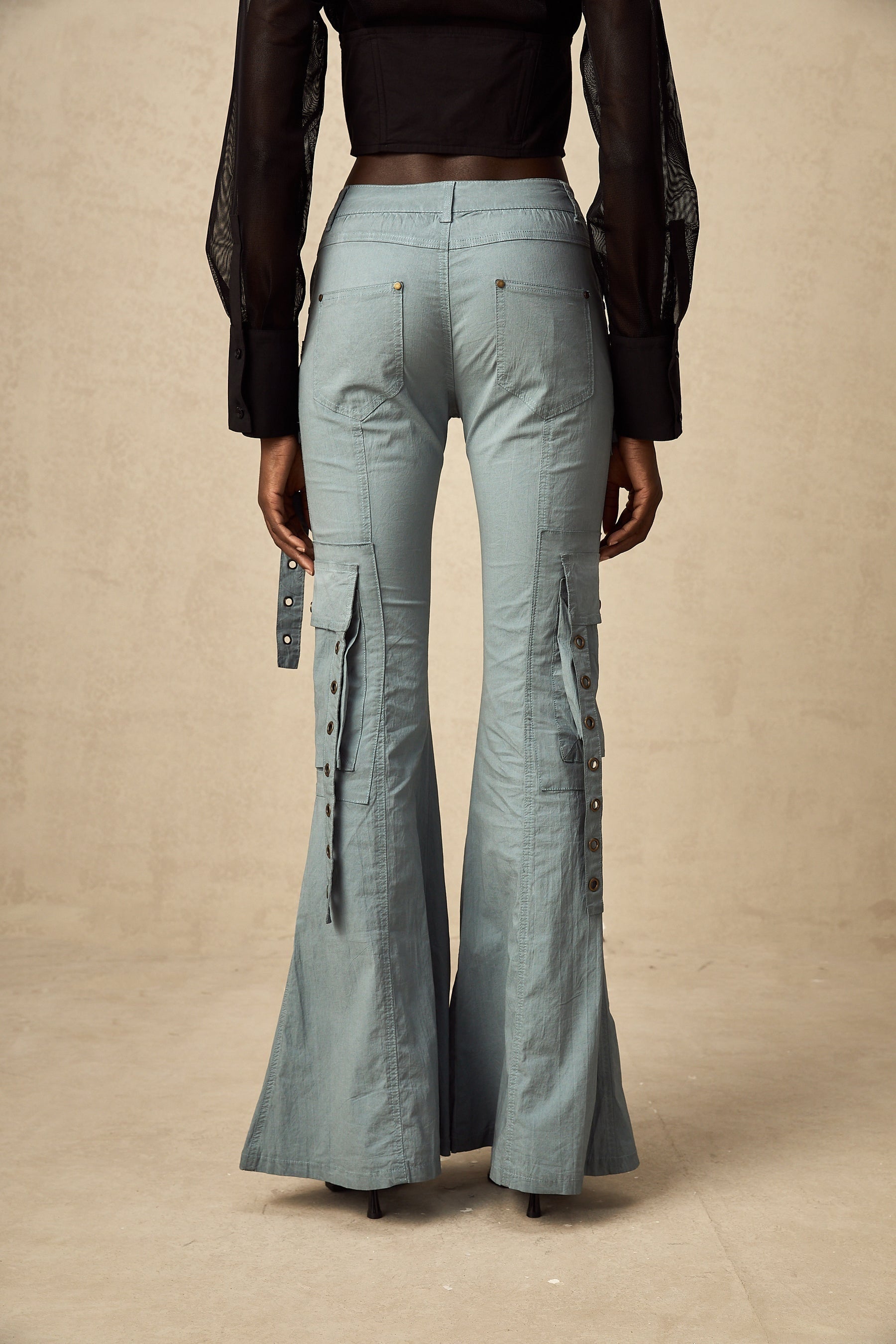 Woman wearing wide leg cargo pants with flared silhouette and belt loops in neutral color