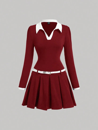 Burgundy contrast collar dress with a pleated skirt, fitted waist, and belt, featuring a polished preppy style with long sleeves and white accents