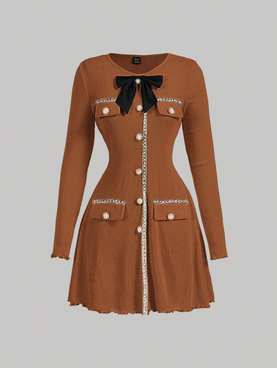 Brown knitted mini dress with pearl buttons, satin bow, and decorative pockets, featuring a tailored fit and ribbed texture for an elegant yet cozy look