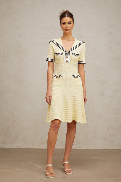 Young girl wearing a yellow knitted dress with sailor collar