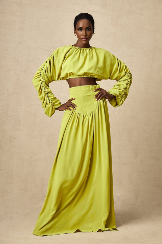 Young girl wearing green smocked top and matching skirt set called Emilie