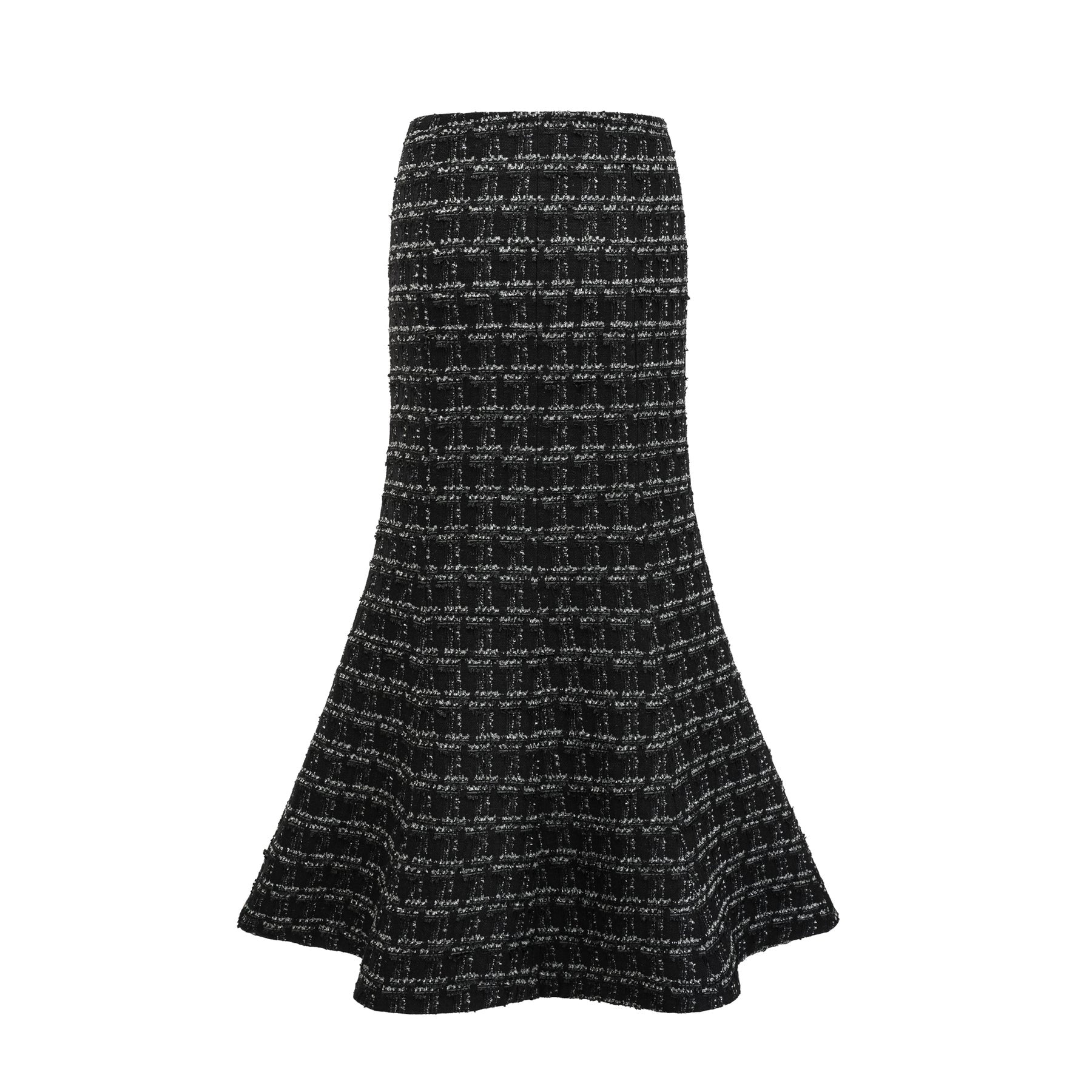 Young woman wearing a black and white checked tweed matching set consisting of a vest top and skirt standing against a plain background