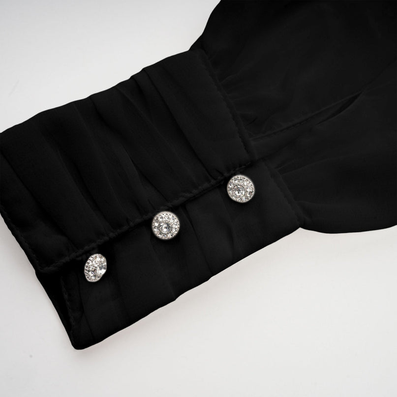 Young woman wearing a black asymmetric tulle blouse and matching skirt set from Andrea collection