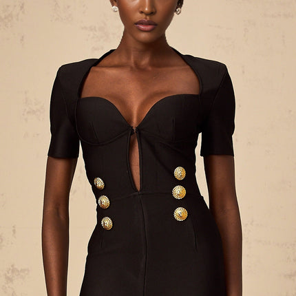 Young woman wearing a black short playsuit with embossed buttons named Solene