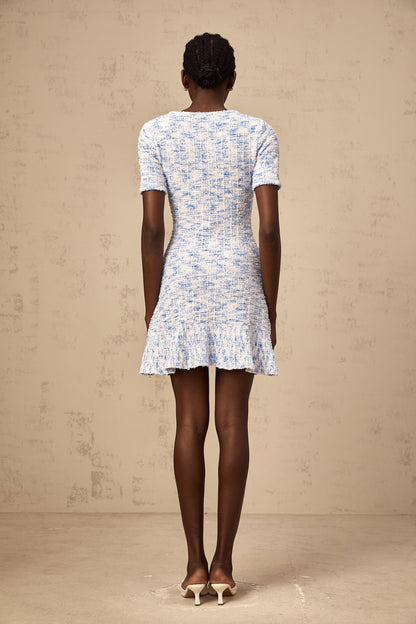 Young woman wearing a blue checked knit mini dress with short sleeves and a fitted silhouette