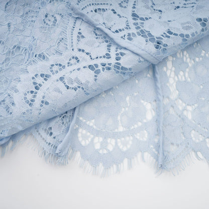 Young woman wearing a blue midi dress with floral lace pattern and boned bodice