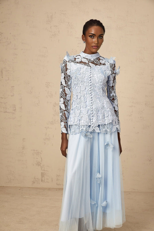 Young woman wearing a blue sequined lace matching set consisting of a sleeveless top and short skirt with shimmering details