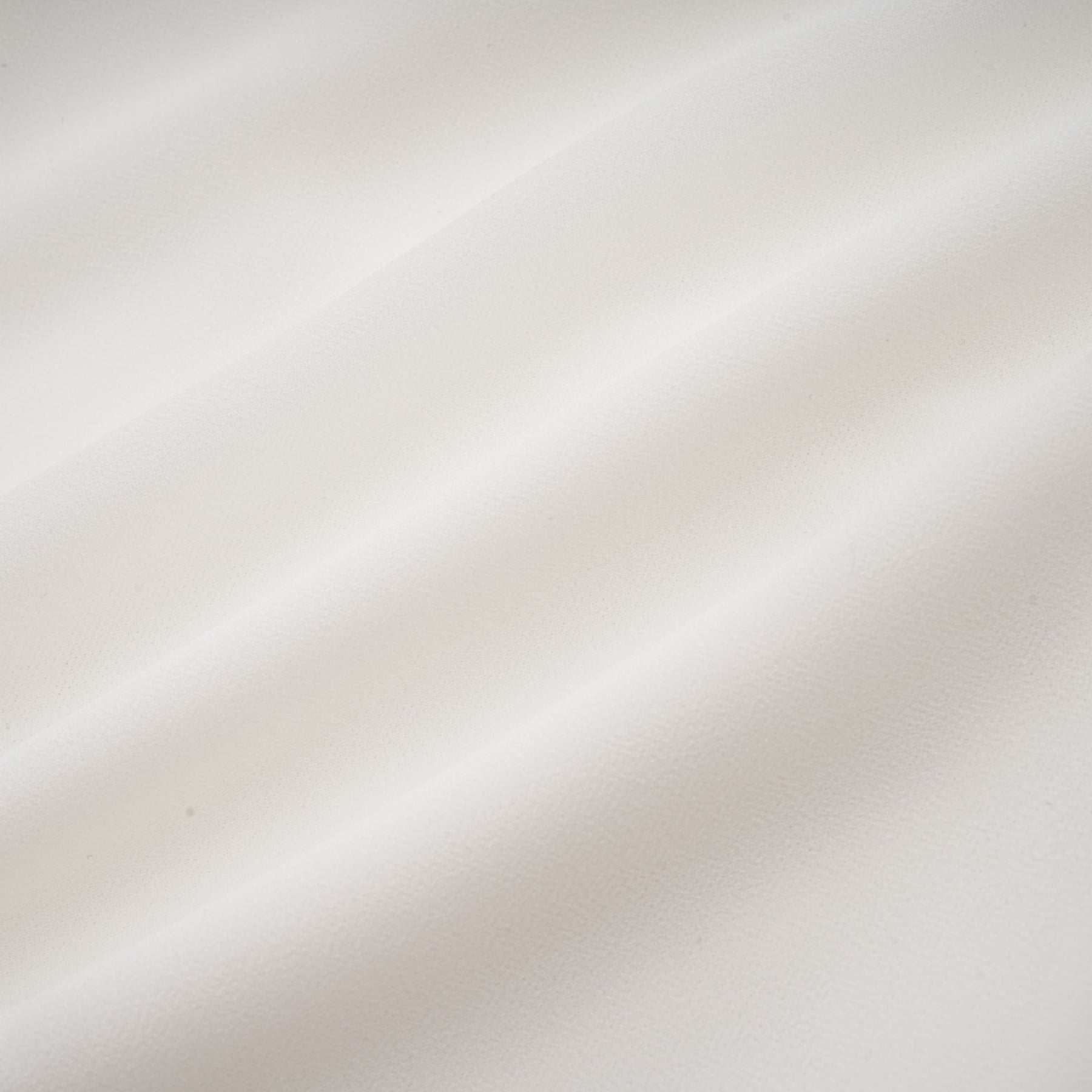Young woman wearing a flowy white chiffon blouse with long sleeves and a relaxed fit