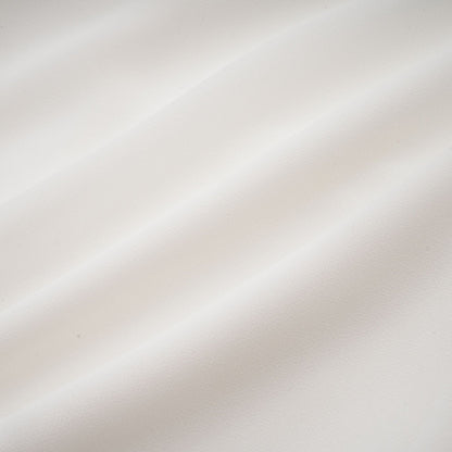 Young woman wearing a flowy white chiffon blouse with long sleeves and a relaxed fit