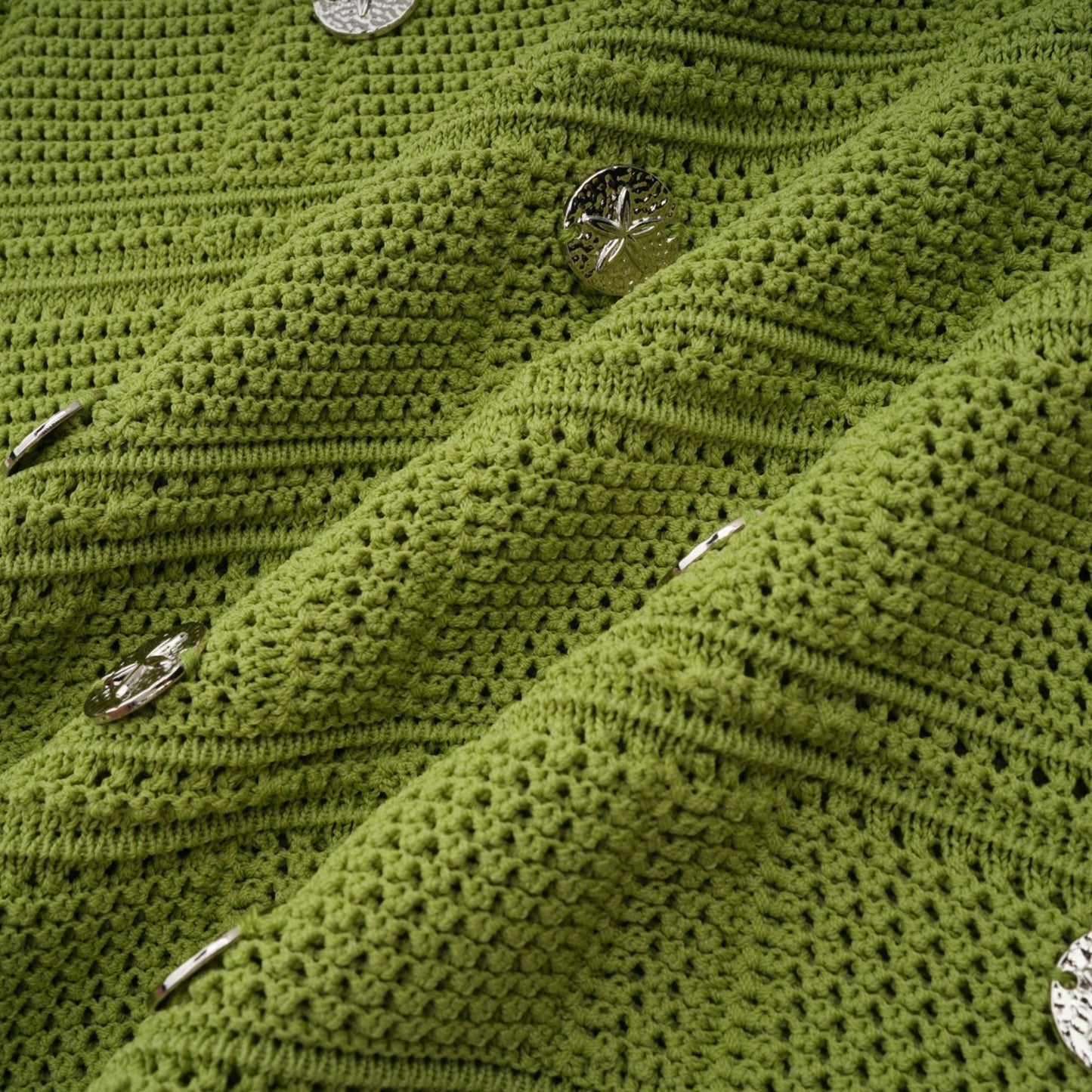 Young woman wearing a green knit top and matching skirt set The top features embellishments and the outfit has a stylish coordinated look