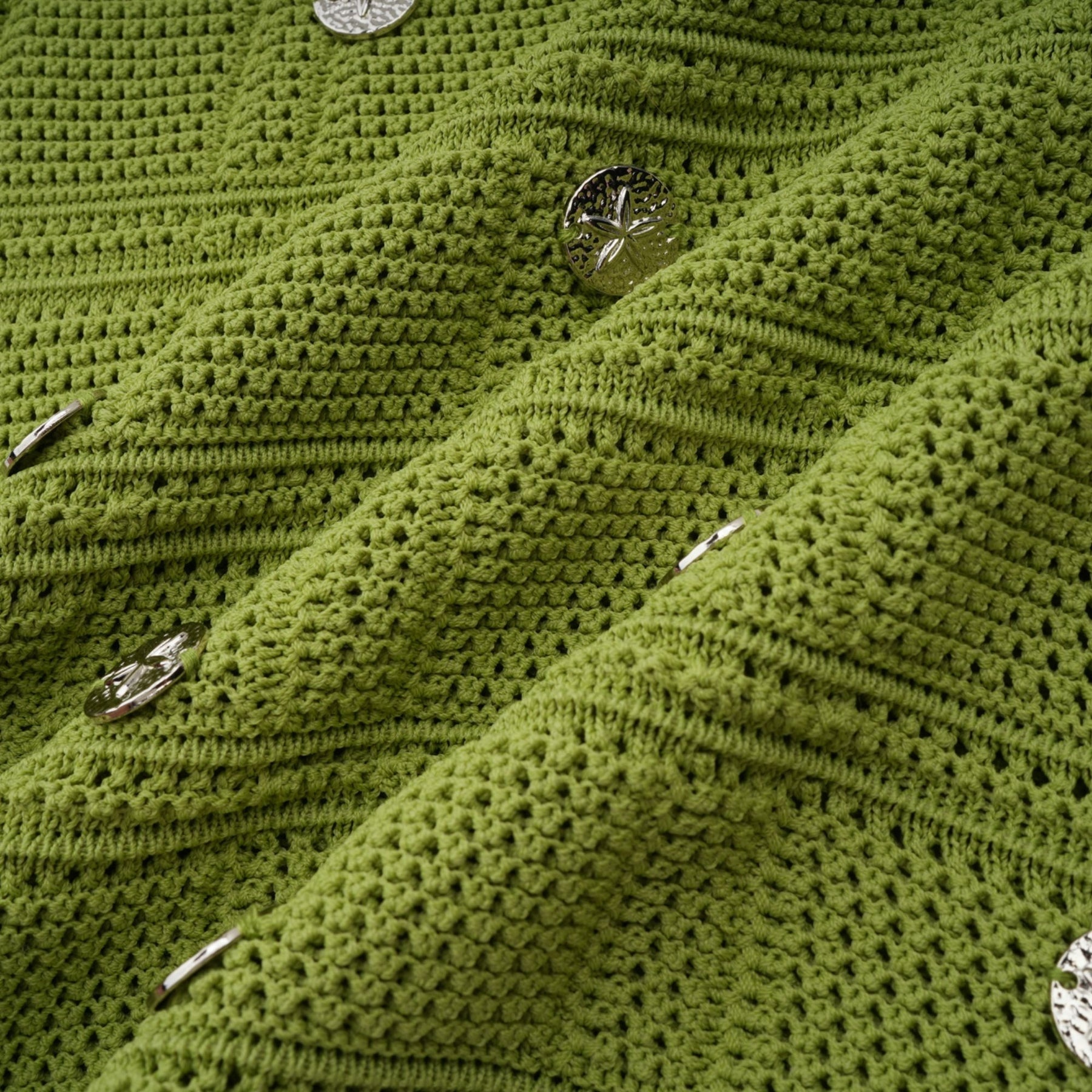 Young woman wearing a green knit top and matching skirt set The top features embellishments and the outfit has a stylish coordinated look