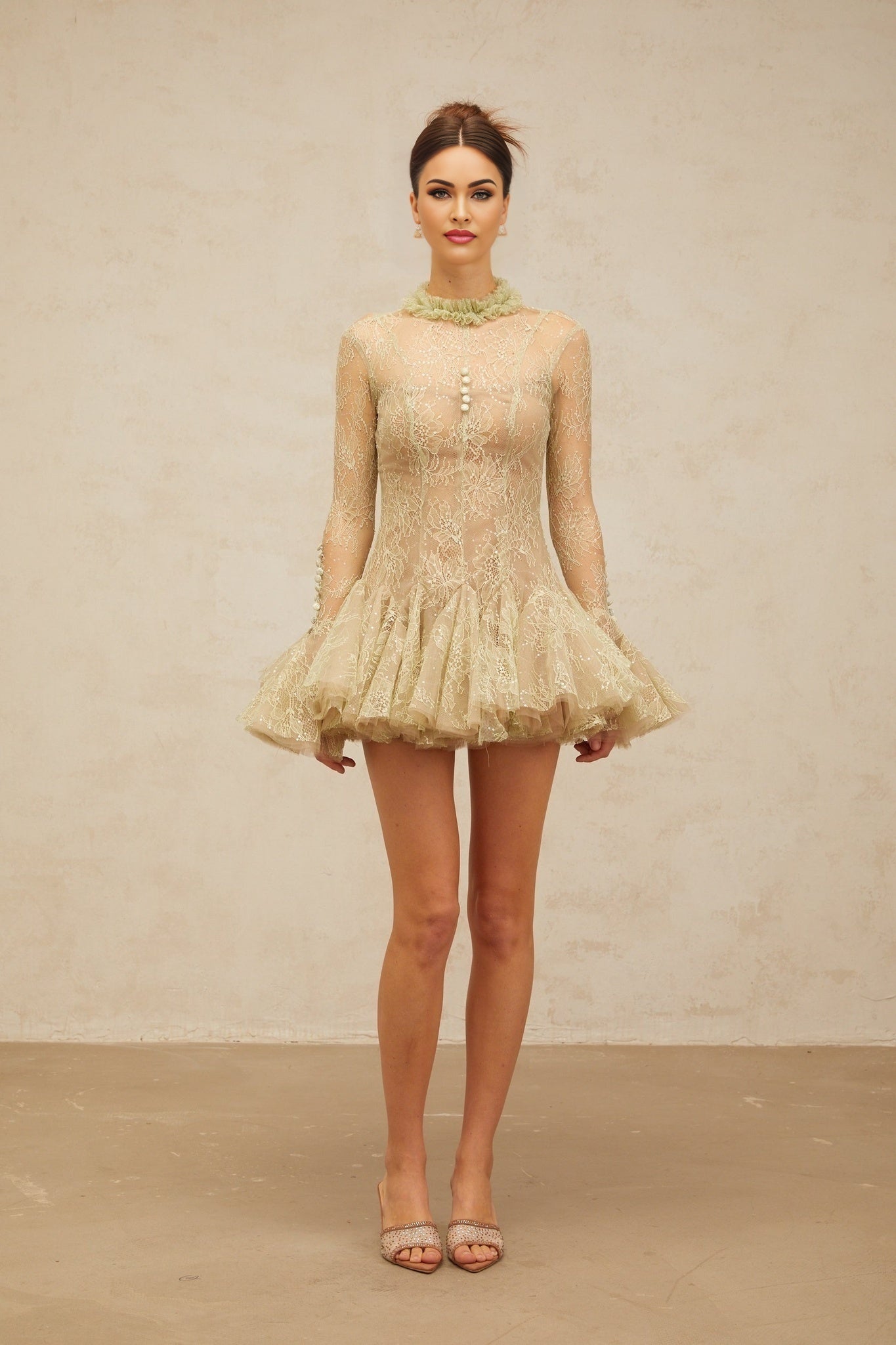 Young woman wearing a green mini dress with floral embroidery and flared skirt