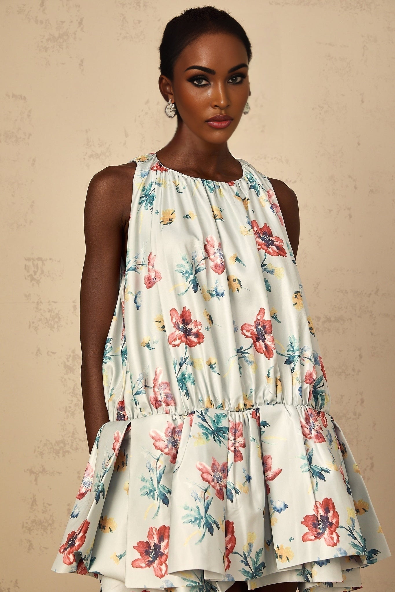 Young woman wearing a green mini dress with floral print and shirred detailing