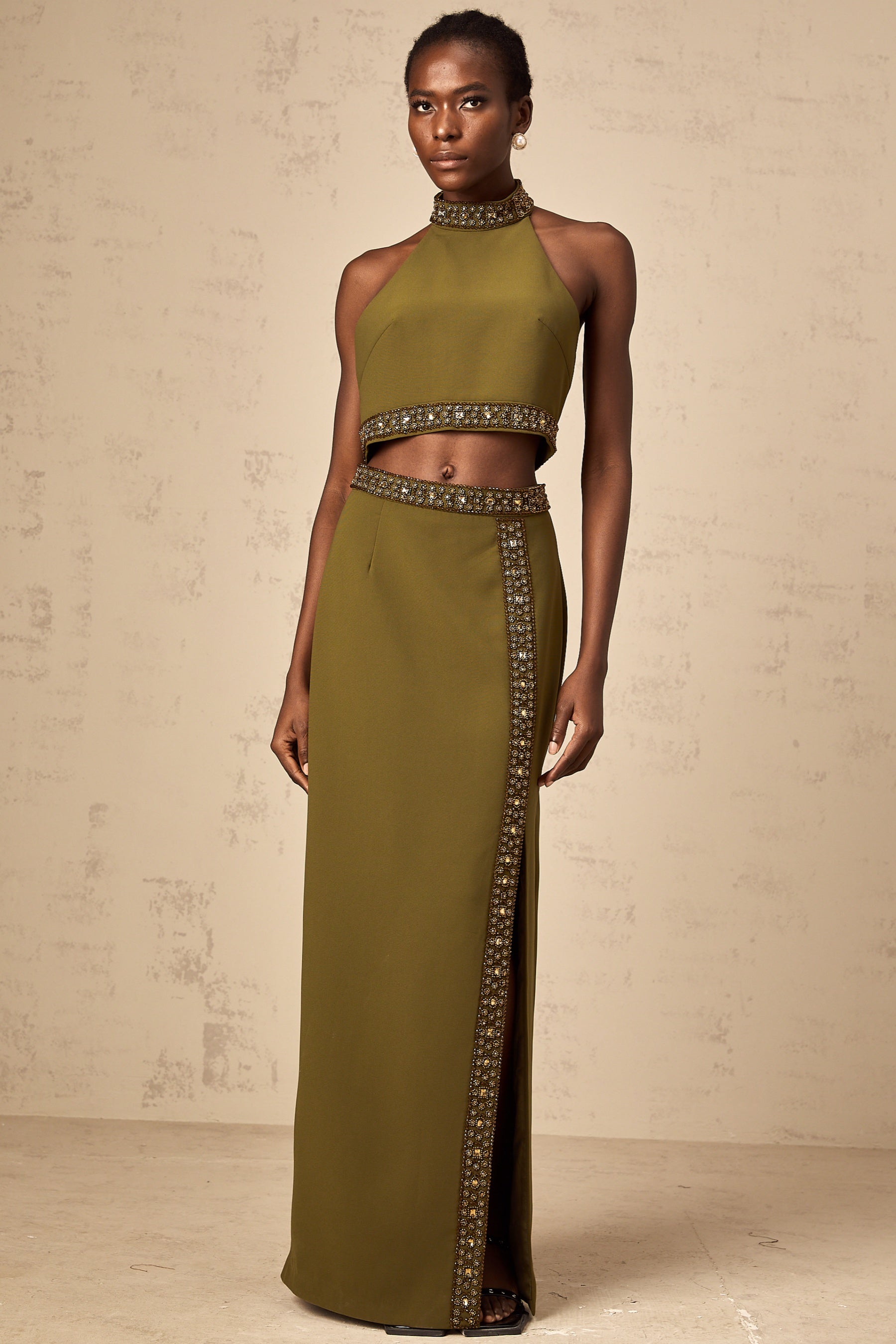 Young woman wearing a light green matching set consisting of a sleeveless beaded trim top and a short skirt with daisy floral pattern and beaded hem