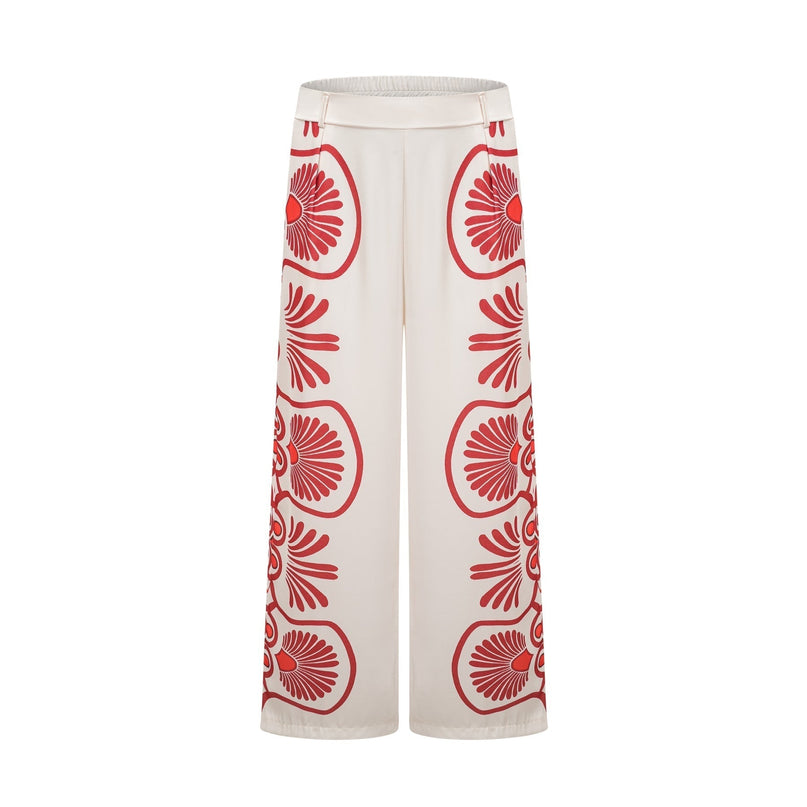 Young woman wearing a matching set consisting of a vibrant graphic print shirt and trousers in bold colors and patterns