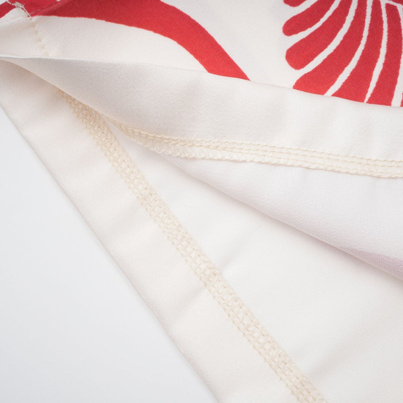 Young woman wearing a matching shirt and trousers set with a colorful graphic print pattern called Amaranta