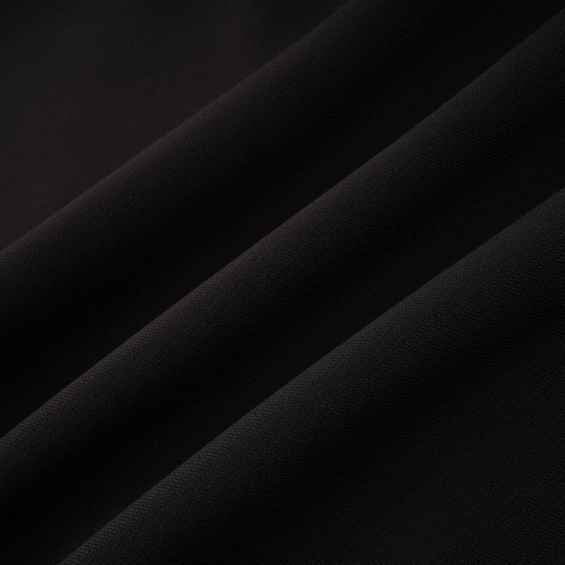 Young woman wearing a short mini dress with contrasting colors and embellishments standing in a stylish pose