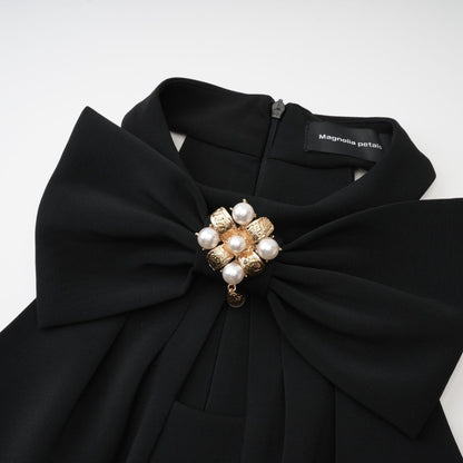 Black sleeveless dress with cutout design featuring bowknot embellishment thigh length straight hem and rear zip fastening Made of 65% viscose 35% polyamide