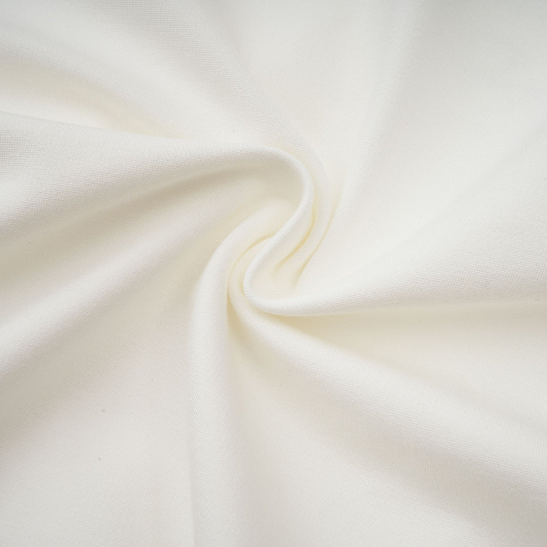 Young woman wearing a white cropped top with ruched detailing on the front and sleeves