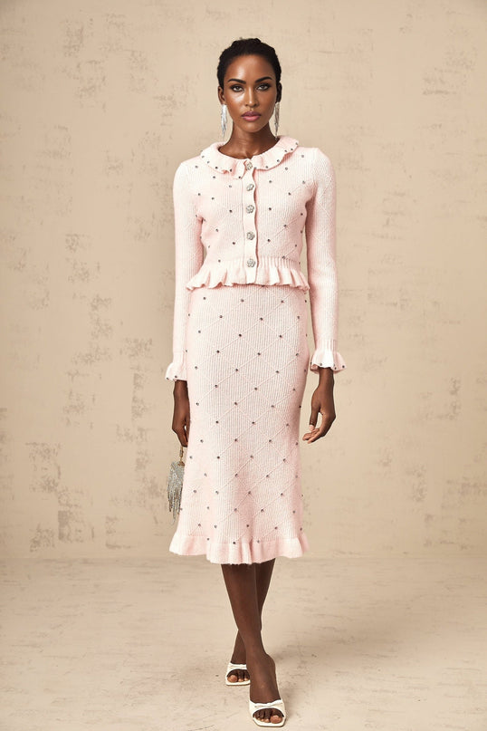 Young woman wearing pink argyle patterned knitted cardigan and matching skirt set styled in retro fashion